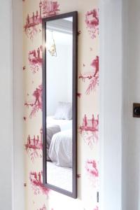 a mirror on a wall next to a bed at Gorgeous 3 bed house in Matlock + Garden ‘lookout’ in Matlock