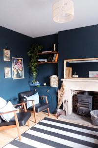 a living room with blue walls and a fireplace at Gorgeous 3 bed house in Matlock + Garden ‘lookout’ in Matlock