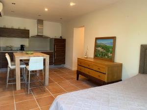 a bedroom with a kitchen and a table with a dining room at Sunrise T2 avec jacuzzi vue mer avec accès jacuzzi et piscine in Porto-Vecchio
