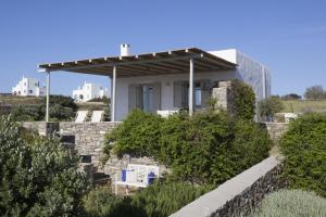 a house on a stone wall with a pergola at Kallisti Daphne · Gorgeous Villa - an oasis for 8 people in Naousa