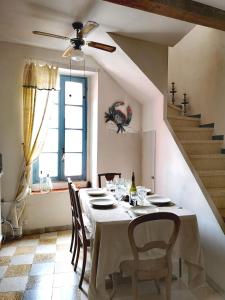 uma sala de jantar com uma mesa com cadeiras e uma ventoinha de tecto em La Tonnelière em Marseillan