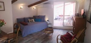 a bedroom with a blue bed and a patio at La Tonnelière in Marseillan