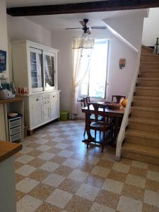 uma sala de jantar com uma mesa e uma escada em La Tonnelière em Marseillan