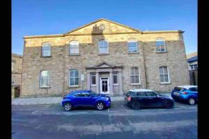 two cars parked in front of a brick building at Creathie Cathcart - Georgian Luxury at the beach in Ayr