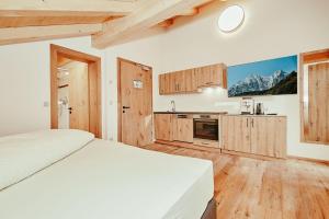 a bedroom with a bed and a kitchen with mountains at Landhotel Berger in Ainring