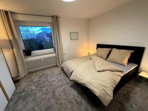 a bedroom with a large bed and a window at Ruhiges Penthouse mit Weitblick in Göttingen