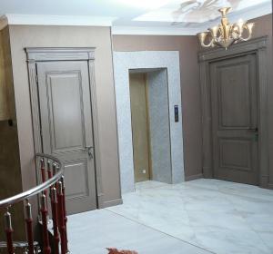 een hal met twee deuren en een kroonluchter bij West inn Hotel & Restaurant in Baku