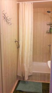a bathroom with a white shower curtain and a tub at Tuhala Jarve Talu in Tuhala