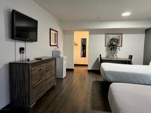 a hotel room with two beds and a flat screen tv at Siegel Slots and Suites (No Resort Fees) in Las Vegas