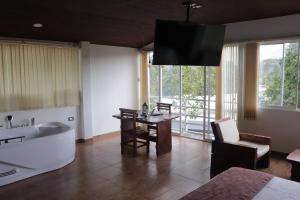 uma casa de banho com uma banheira, uma mesa e um lavatório. em Hotel Campestre La Posada Del Rancho em Popayán