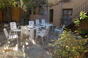 un grupo de mesas y sillas blancas en un patio en CTR. El Convento, en El Bodón