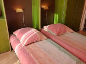 ホークジールにあるFerienwohnung Goldblume Hooksiel Nordseeのピンクの枕2つ(1室のベッドに座る)