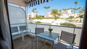un balcone con tavolo, sedie e palme di Europa 400 a Maspalomas