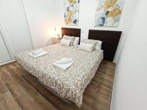 una camera da letto con un letto con due asciugamani sopra di Europa 400 a Maspalomas Altre 13 foto