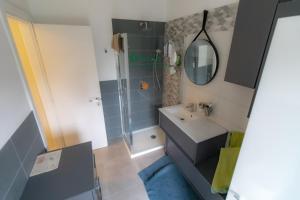 un piccolo bagno con lavandino e doccia di WELCOME HOME - CAMERA privata in Appartamento Condiviso a RHO a Rho