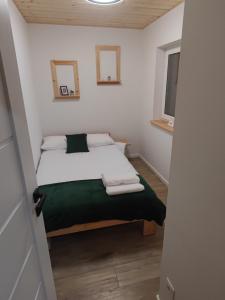 ein kleines Schlafzimmer mit einem Bett in einem Zimmer in der Unterkunft Między Drzewami in Biecz