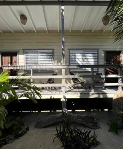 a porch of a house with a white railing at DreamCabanas in Caye Caulker