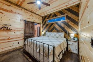 une chambre avec un lit dans une pièce aux murs en bois dans l'établissement Fireside Creek Luxury Cabin, à Stephens Gap