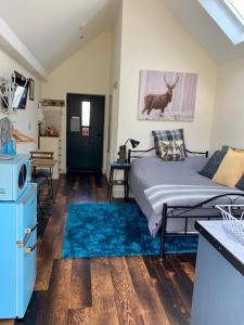 ein Schlafzimmer mit einem Bett und einem blauen Teppich in der Unterkunft The Snug in Cheltenham, Leckhampton - A Cosy & Unique Space in Cheltenham