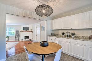 a kitchen with a wooden table and white cabinets at Bright Boynton Beach Getaway with Patio! in Boynton Beach