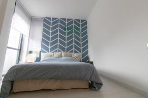 una camera con un letto con una parete blu e bianca di WELCOME HOME - CAMERA privata in Appartamento Condiviso a RHO a Rho