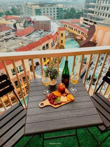 a table with a plate of food and wine glasses on a balcony at NEW Modern Venice Best View and Balcony, Fast Wifi at McKinley Hill 1BR interconnected to Venice Grand Canal Mall in Manila