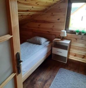 niewielka sypialnia z łóżkiem i oknem w obiekcie Domek Na Roztoczu w mieście Tomaszów Lubelski