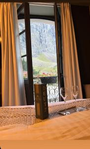 uma mesa com dois copos de vinho e uma janela em Hôtel du cirque et de la cascade em Gavarnie