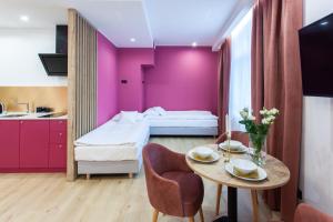 a hotel room with a purple accent wall at SQUARE APARTMENTS GDYNIA in Gdynia