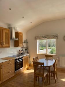a kitchen with a table and chairs and a window at Pine Lodge in Lisnaskea