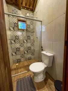 a small bathroom with a toilet and a window at Pousada Flor de Laranjeira in Goiás