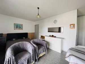 a bedroom with two beds and a tv on the wall at Appartement Cambo-les-Bains, 1 pièce, 2 personnes - FR-1-495-16 in Cambo-les-Bains