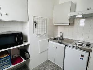 a small kitchen with white cabinets and a sink at Appartement Cambo-les-Bains, 1 pièce, 2 personnes - FR-1-495-16 in Cambo-les-Bains