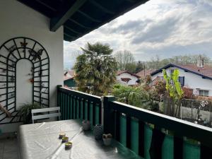 einen Balkon mit einem Tisch und Blick auf ein Haus in der Unterkunft Appartement Cambo-les-Bains, 2 pièces, 2 personnes - FR-1-495-58 in Cambo-les-Bains