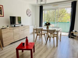 sala de estar con mesa de comedor y TV en Appartement Cambo-les-Bains, 2 pièces, 2 personnes - FR-1-495-46, en Cambo-les-Bains