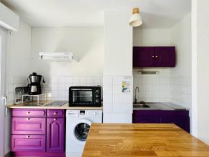 cocina con armarios morados y microondas en Appartement Cambo-les-Bains, 2 pièces, 2 personnes - FR-1-495-46, en Cambo-les-Bains