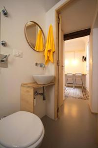 Un baño con inodoro, lavabo y espejo. en Trame Tramari, en Trapani