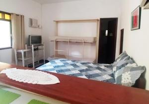 una piccola camera con letto e TV di Suites Americanas Em Jaconé a Jaconé