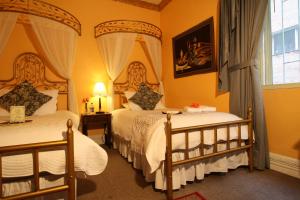 1 Schlafzimmer mit 2 Betten und einem Fenster in der Unterkunft City Art Hotel Silberstein in Quito