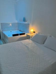 ポンペイにあるCostantino Homeのベッドルーム(白いベッド1台、バスタブ付)