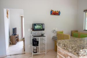 un salon avec une télévision et une table dans l'établissement Chacara com piscina e lazer em Jaboticatubas MG, à Jaboticatubas