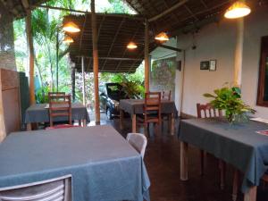 un restaurante con mesas y sillas y un coche en Sansala Guesthouse & Restaurant, en Tangalle