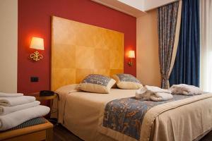 a bedroom with two beds with towels on them at Hotel Luna Riccione e Aqua Spa Only Adults +12 in Riccione