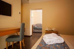 リッチョーネにあるHotel Luna Riccione e Aqua Spa Only Adults +12のデスク、椅子、ベッドが備わる客室です。