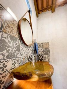 a bathroom with a stone sink with a mirror at Pousada Flor de Laranjeira in Goiás