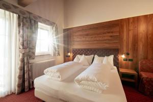 A bed or beds in a room at Hotel Chalet Sas Morin