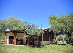 a small house in a field with trees at Peumayen Cabañas in Villa Las Rosas