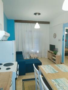 a kitchen and a living room with a blue couch at Vaso Manos Apartment - Siviri Chalkidiki in Siviri +29 photos