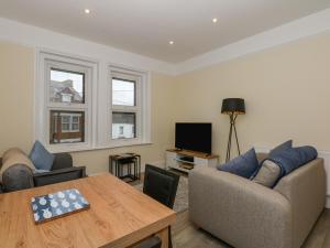 a living room with a couch and a table at Sea Breeze Apartment No 7 in Hunstanton