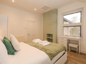 a bedroom with a bed with a desk and a window at Sea Breeze Apartment No 7 in Hunstanton